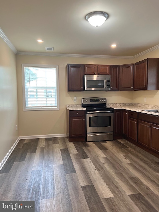 417 Bailey Ln, Salisbury, MD 21801 - kitchen featuring stainless steel appliances, light countertops, dark brown cabinets, ornamental molding, and dark wood-style floors
