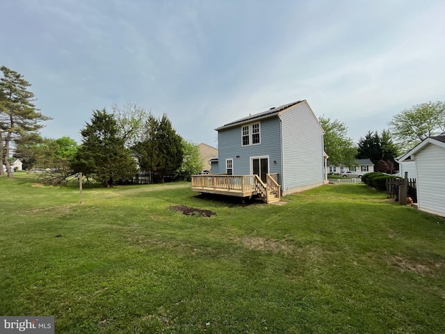 back of property with a yard and a deck