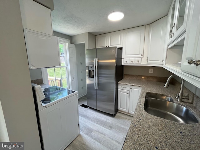 kitchen featuring stainless steel refrigerator with ice dispenser, white electric range, light wood-type flooring, white cabinets, and a sink
