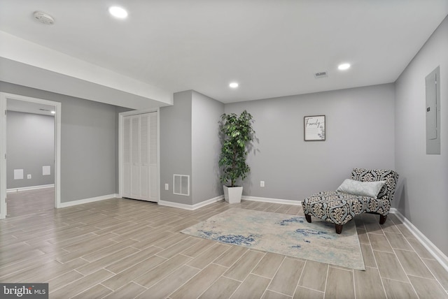 living area featuring baseboards, wood tiled floor, and visible vents