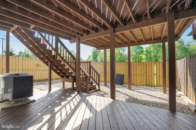 deck with stairs, a fenced backyard, and central air condition unit