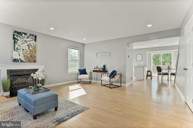 living area with recessed lighting, baseboards, and light wood finished floors