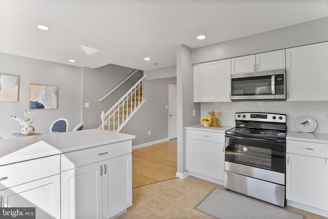 kitchen featuring recessed lighting, light countertops, appliances with stainless steel finishes, and white cabinets