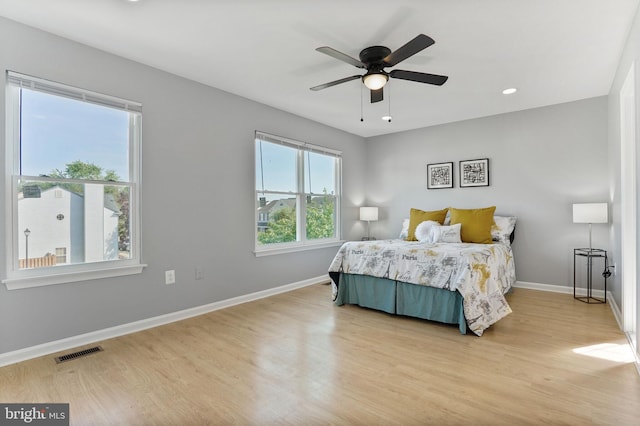 bedroom with ceiling fan, visible vents, wood finished floors, baseboards, and recessed lighting