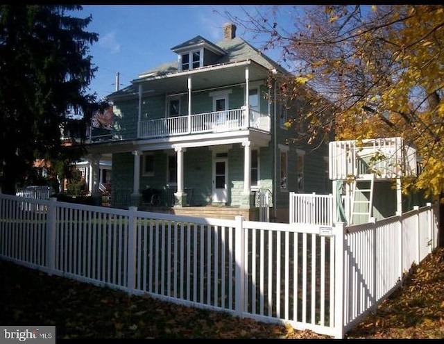 9 Queen St N, Shippensburg, PA 17257 - rear view of property featuring covered porch, a balcony, a chimney, and a fenced front yard