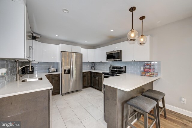 34 Pittman Ln, Sicklerville, NJ 08081 - kitchen with a sink, stainless steel appliances, white cabinetry, a peninsula, and backsplash