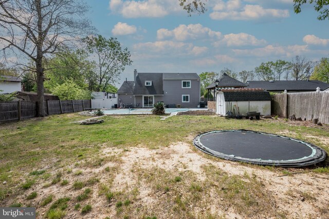 34 Pittman Ln, Sicklerville, NJ 08081 - view of yard featuring a trampoline, a storage shed, a fenced backyard, an outdoor structure, and a covered pool