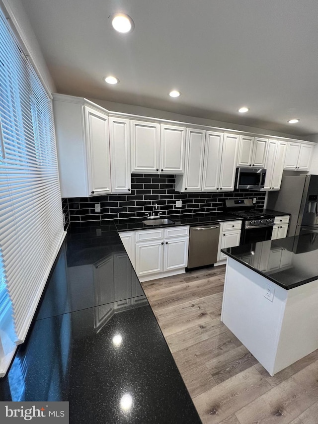 6232 N 10th St, Philadelphia, PA 19141 - kitchen with dark countertops, backsplash, appliances with stainless steel finishes, and white cabinets