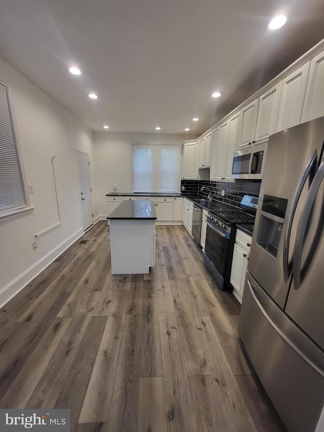 6232 N 10th St, Philadelphia, PA 19141 - kitchen featuring dark countertops, tasteful backsplash, stainless steel appliances, white cabinets, and dark wood-style flooring