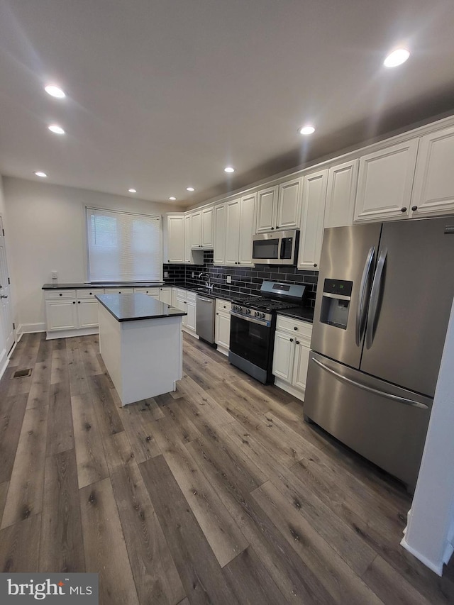 6232 N 10th St, Philadelphia, PA 19141 - kitchen featuring stainless steel appliances, dark wood-style floors, dark countertops, and tasteful backsplash