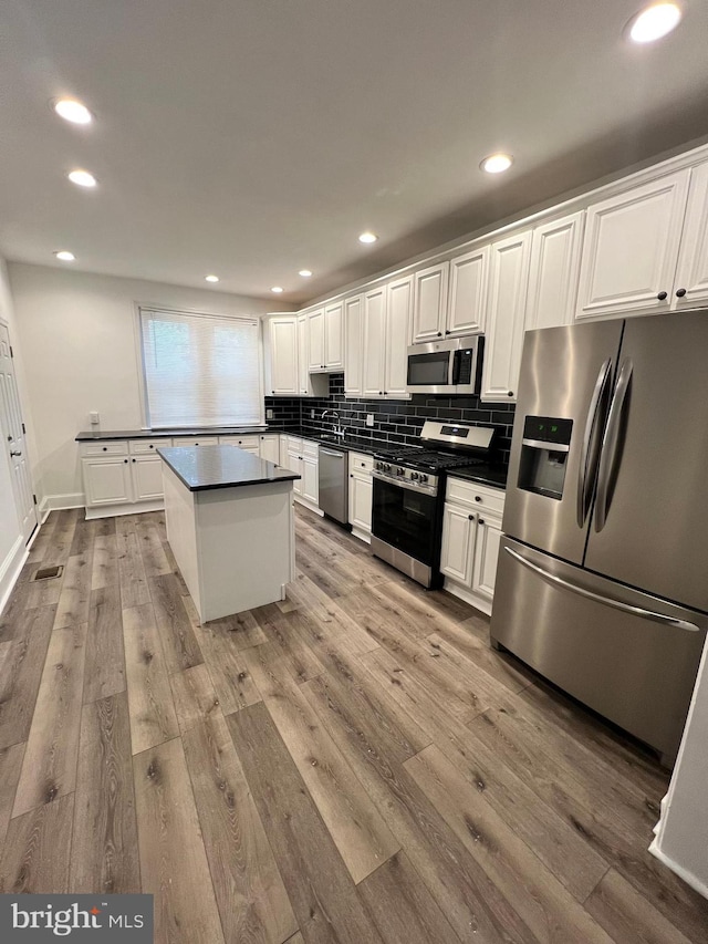 6232 N 10th St, Philadelphia, PA 19141 - kitchen with dark countertops, tasteful backsplash, light wood-type flooring, stainless steel appliances, and white cabinetry