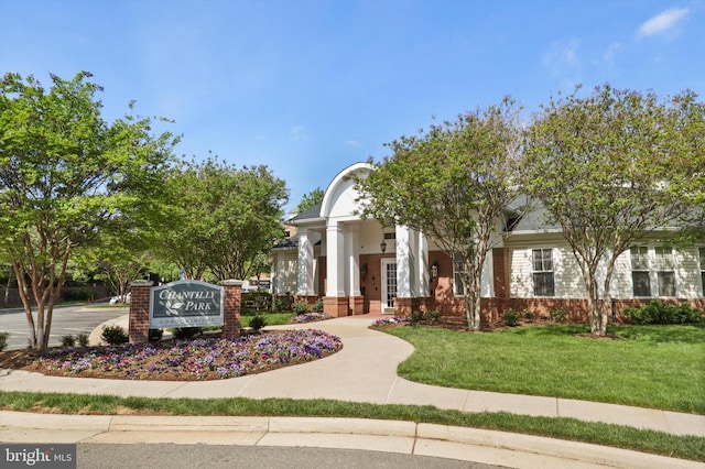 view of front of property featuring a front lawn and brick siding