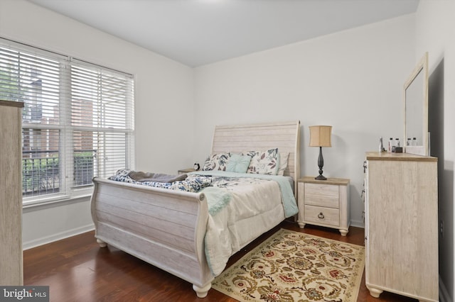 bedroom with baseboards, dark wood-style floors, and multiple windows
