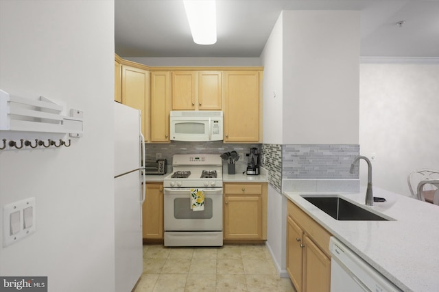 kitchen featuring white appliances, backsplash, a sink, and light brown cabinets