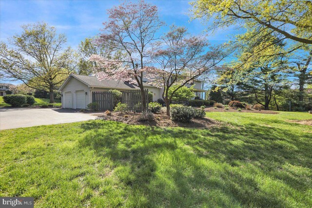 view of front of home with concrete driveway, an attached garage, and a front lawn