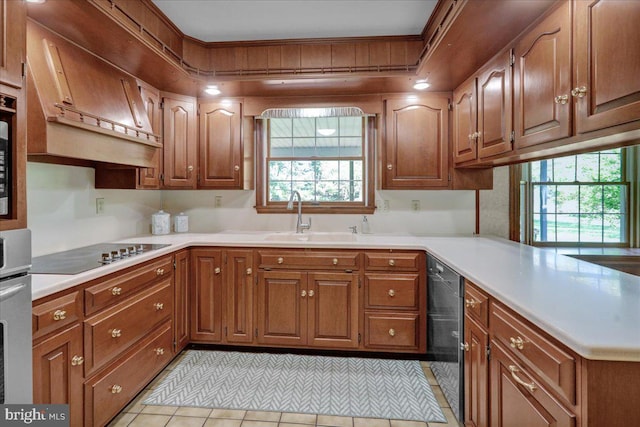 kitchen featuring a sink, premium range hood, a peninsula, black electric stovetop, and dishwashing machine