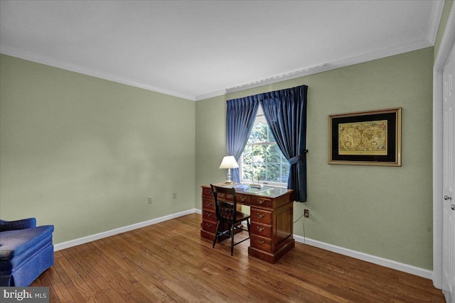 office space featuring baseboards, ornamental molding, and wood finished floors