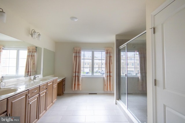 bathroom featuring double vanity, a stall shower, and a sink