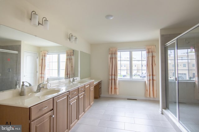 bathroom featuring tile patterned flooring, double vanity, visible vents, a sink, and a stall shower