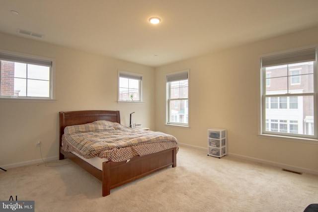 carpeted bedroom with visible vents and baseboards