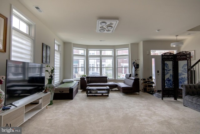 carpeted living room featuring visible vents and a wealth of natural light