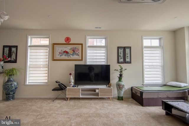 living area with carpet flooring, visible vents, and a wealth of natural light