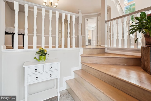 stairway with a notable chandelier