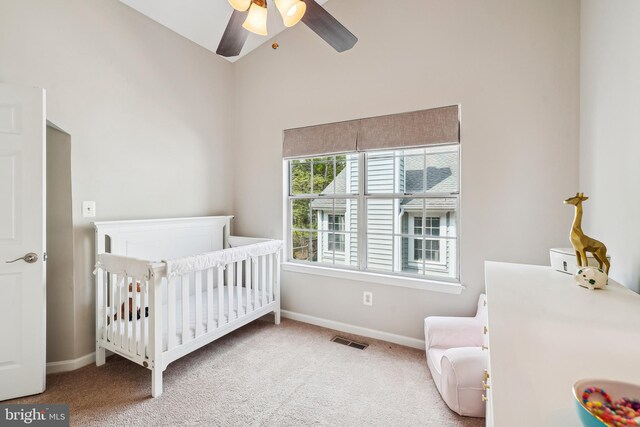 bedroom with visible vents, a nursery area, carpet, and baseboards