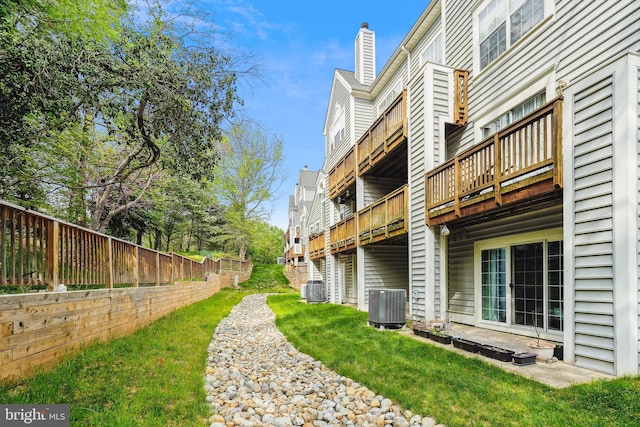 view of yard featuring fence, a deck, and cooling unit