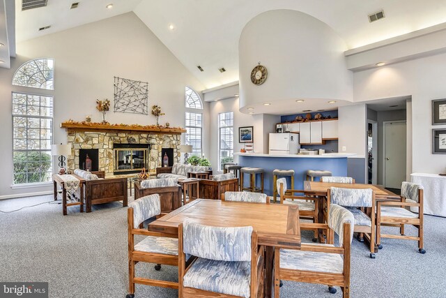 dining room featuring recessed lighting, a fireplace, high vaulted ceiling, visible vents, and carpet