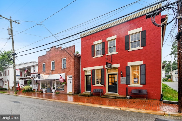 multi unit property with a residential view, entry steps, and brick siding