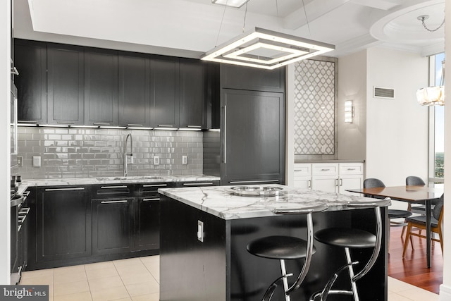 1414 S Penn Sq Unit 34B, Philadelphia, PA 19102 - kitchen with dark cabinets, decorative backsplash, paneled fridge, a sink, and visible vents