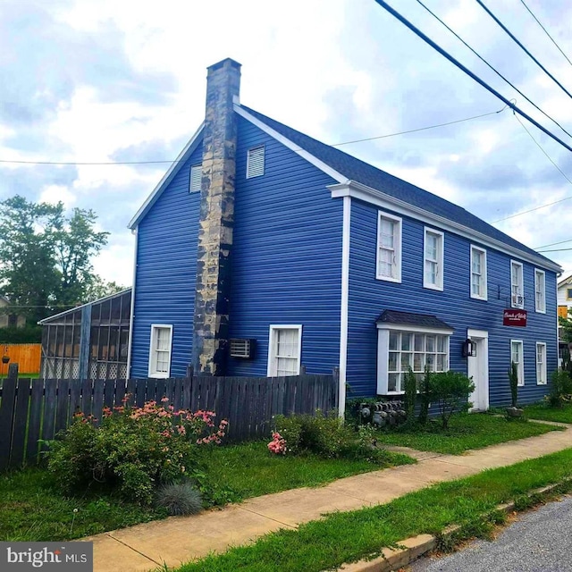 view of home's exterior with fence and a chimney