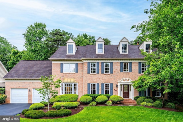 12600 Tolman Rd, Fairfax, VA 22033 - georgian-style home featuring asphalt driveway, brick siding, a front yard, and a garage