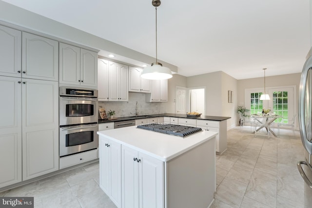 12600 Tolman Rd, Fairfax, VA 22033 - kitchen featuring appliances with stainless steel finishes, a peninsula, a center island, tasteful backsplash, and decorative light fixtures