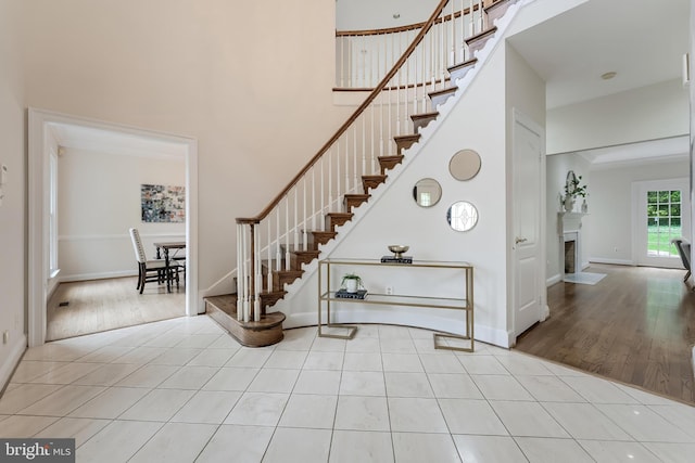 12600 Tolman Rd, Fairfax, VA 22033 - stairway with a towering ceiling, a fireplace with flush hearth, tile patterned flooring, and baseboards