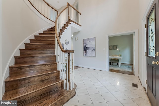 12600 Tolman Rd, Fairfax, VA 22033 - foyer entrance with a high ceiling, stairs, light tile patterned floors, and baseboards