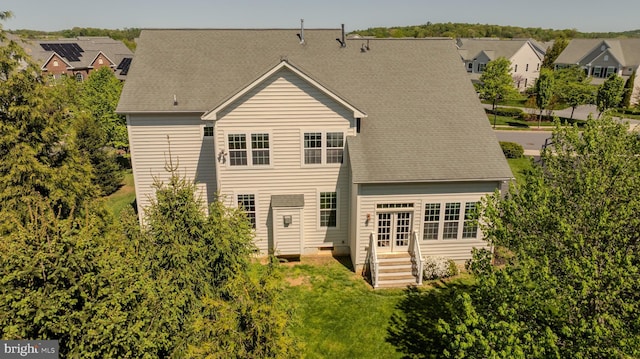 back of house featuring a lawn, a residential view, and french doors