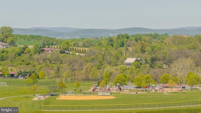 surrounding community with a mountain view and a yard