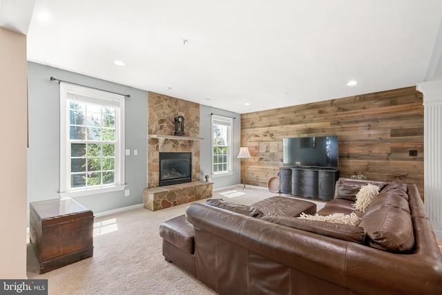 living area featuring wooden walls, carpet floors, a stone fireplace, recessed lighting, and baseboards