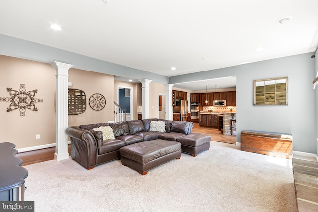 living room with decorative columns, stairs, baseboards, light carpet, and recessed lighting