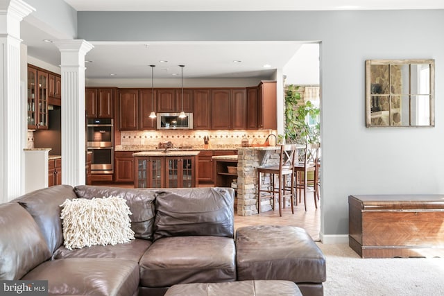 living room with baseboards, decorative columns, recessed lighting, and light colored carpet