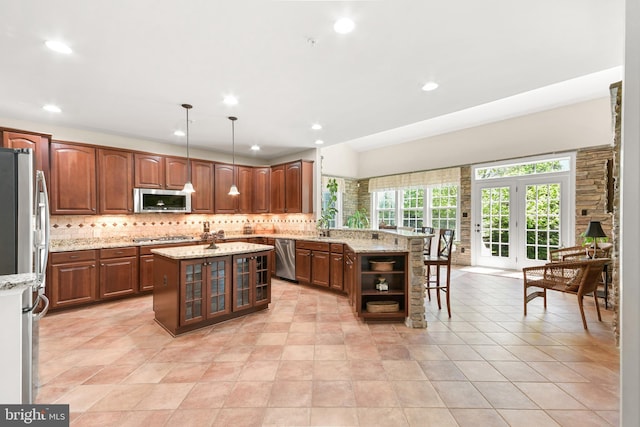 kitchen with backsplash, a peninsula, glass insert cabinets, stainless steel appliances, and recessed lighting