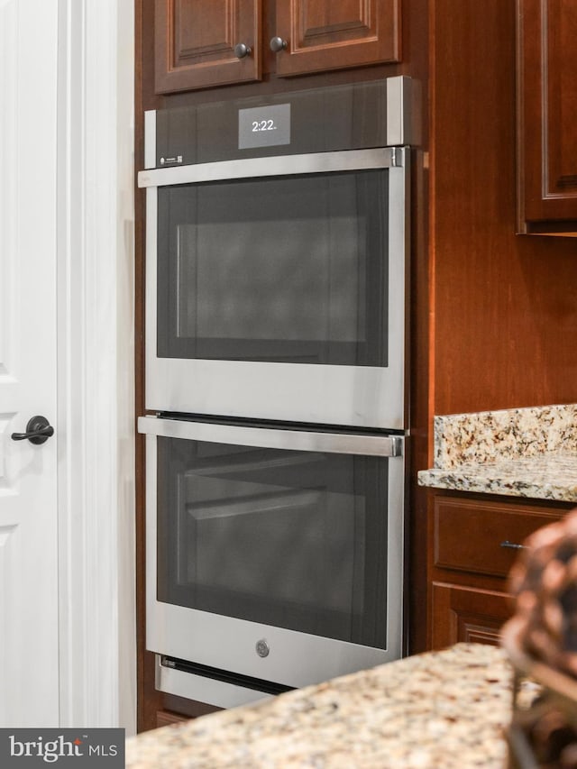 interior details with stainless steel double oven and light stone counters