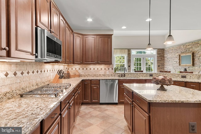 kitchen featuring a sink, light stone counters, tasteful backsplash, and stainless steel appliances