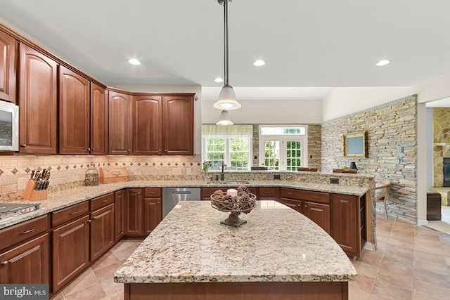 kitchen with a kitchen island, tasteful backsplash, dishwasher, light stone counters, and a peninsula