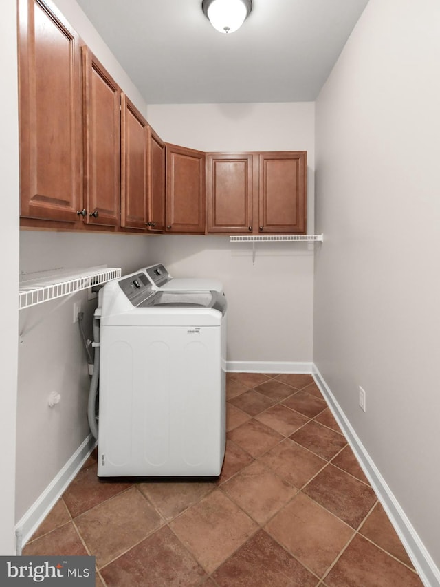 laundry area featuring baseboards, cabinet space, and washer and dryer