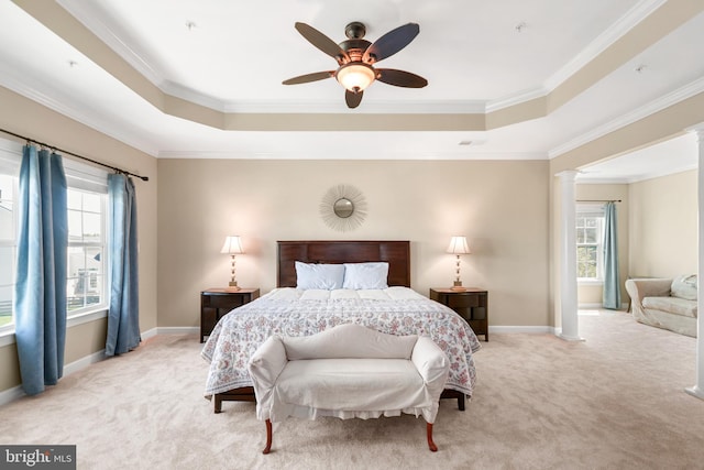 bedroom with ornate columns, a tray ceiling, light carpet, and multiple windows