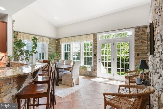 sunroom with french doors, tile patterned floors, a sink, and lofted ceiling