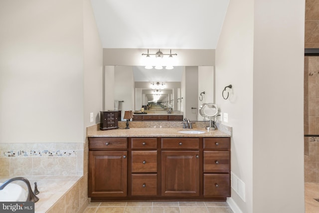 full bath with a relaxing tiled tub, visible vents, and vanity